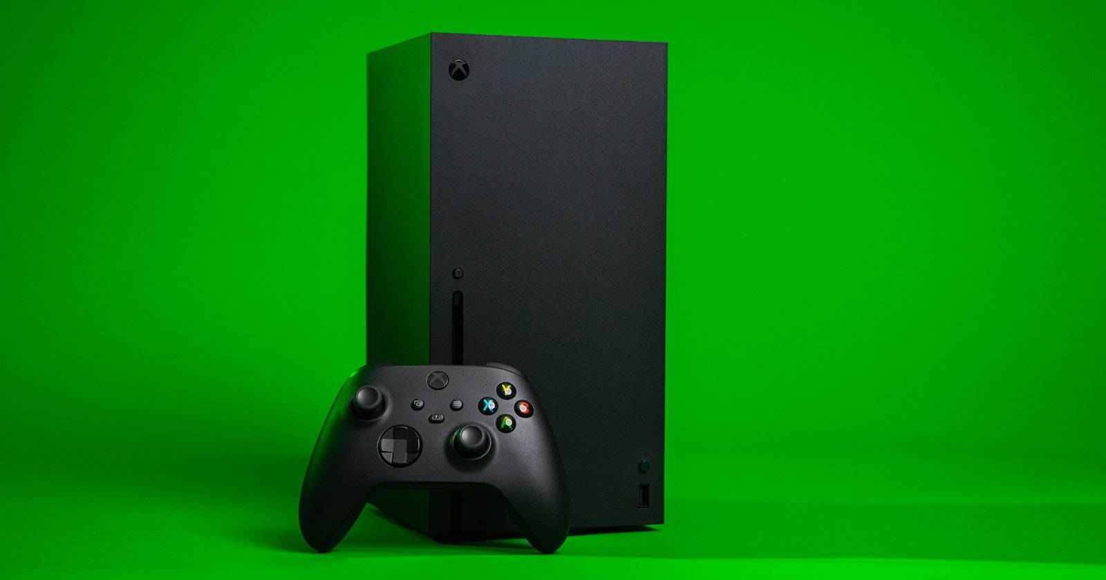 Xbox Series X с контроллером на зелёном фоне