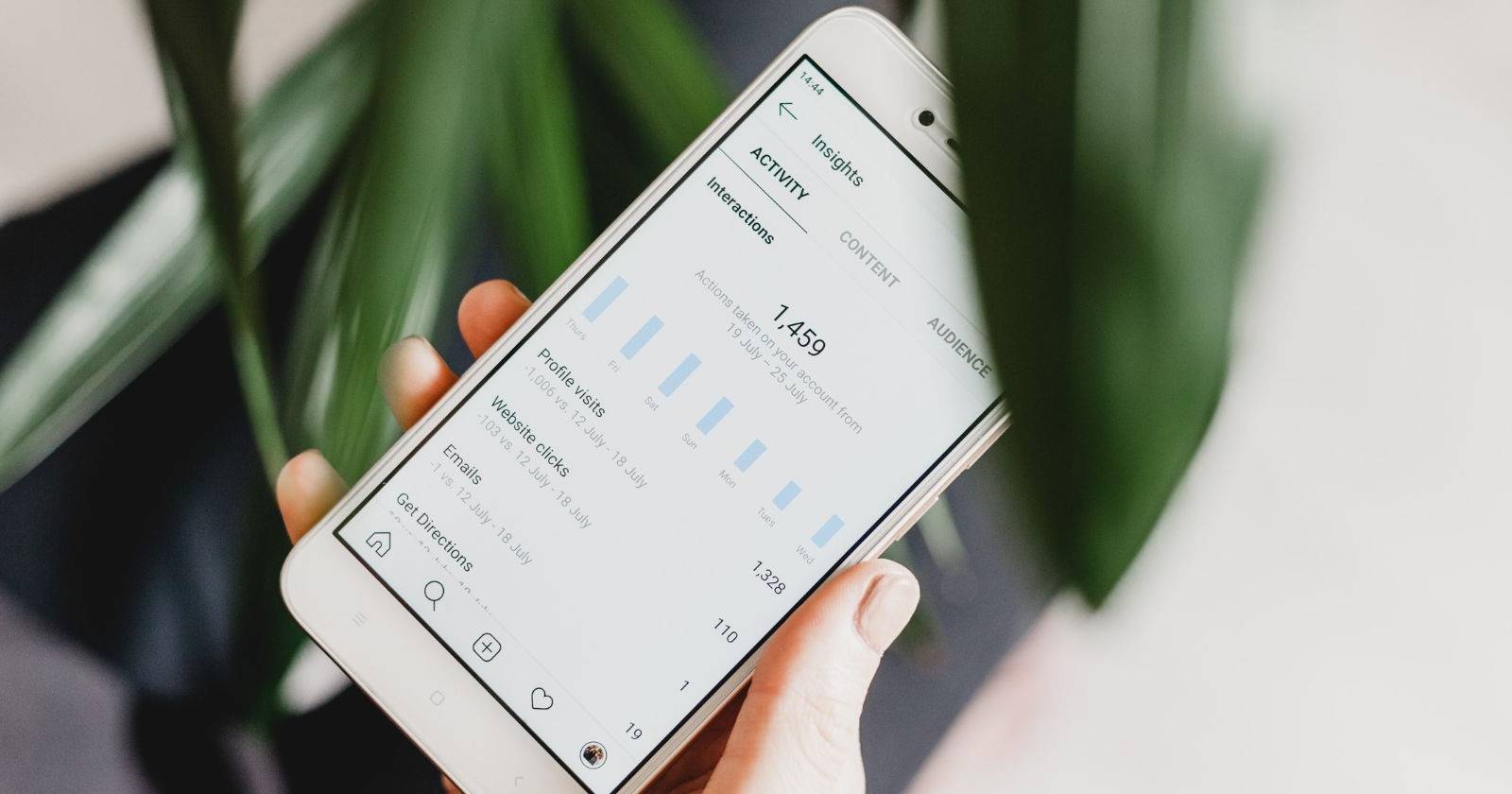 Женщина держит телефон с экраном Instagram Insights