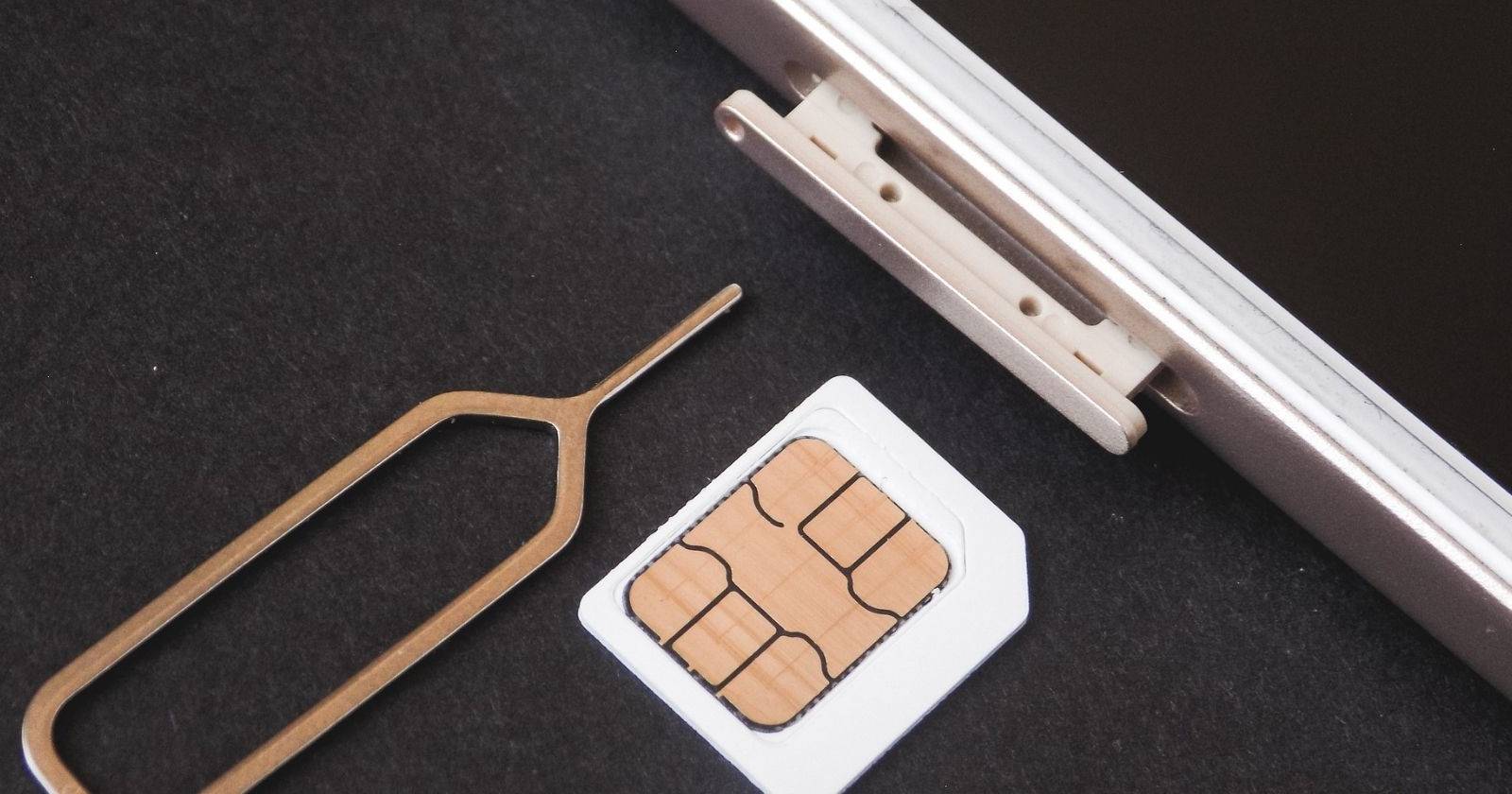 SIM-карта и инструмент для извлечения SIM рядом с iPhone.
