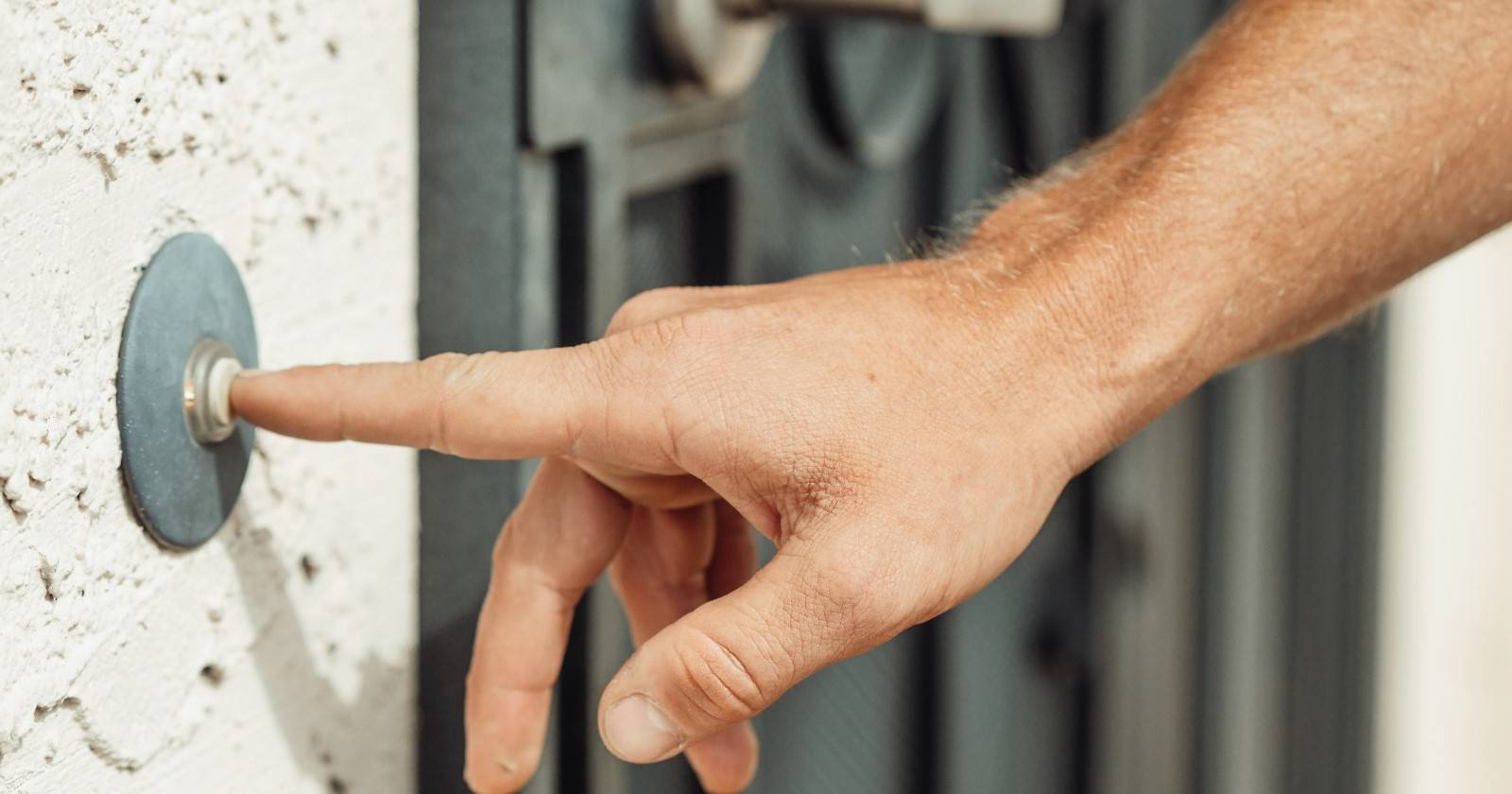 Крупный план руки, нажимающей на дверной звонок