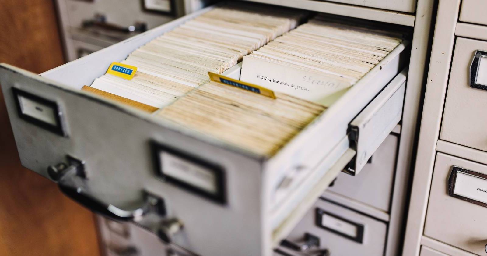 Крупный план открытого ящика картотеки с множеством отдельных карточек
