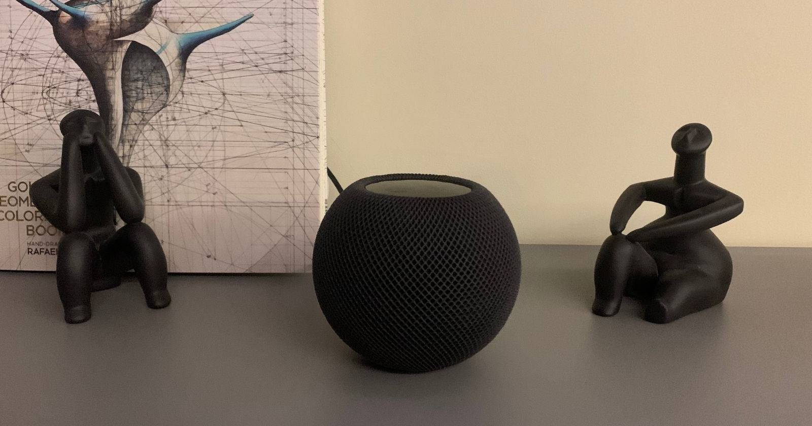 HomePod mini между двумя маленькими статуэтками