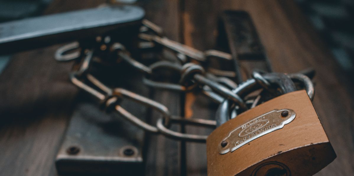 Навесной замок с цепью на деревянной двери