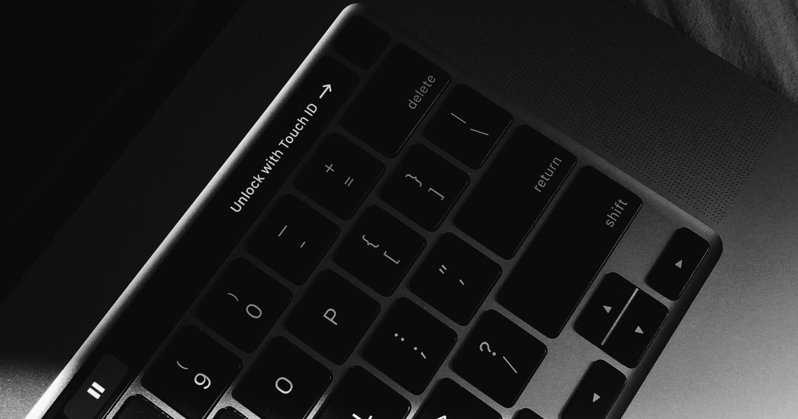 MacBook клавиатура с Touch ID и текстом «разблокировать с помощью Touch ID»