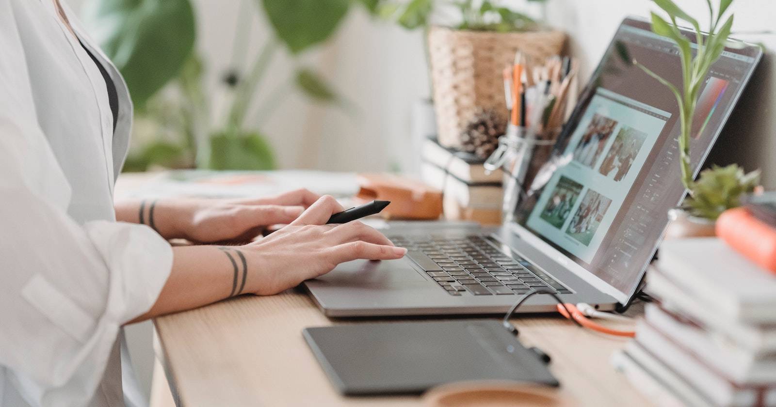 Человек за столом редактирует файлы на ноутбуке