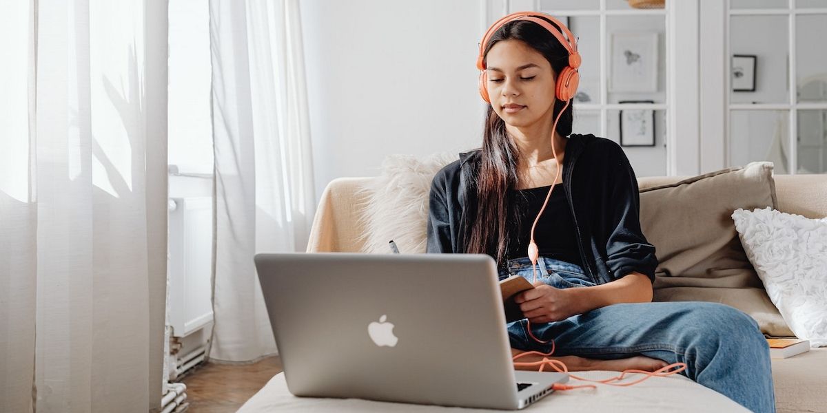 Женщина использует ноутбук в наушниках