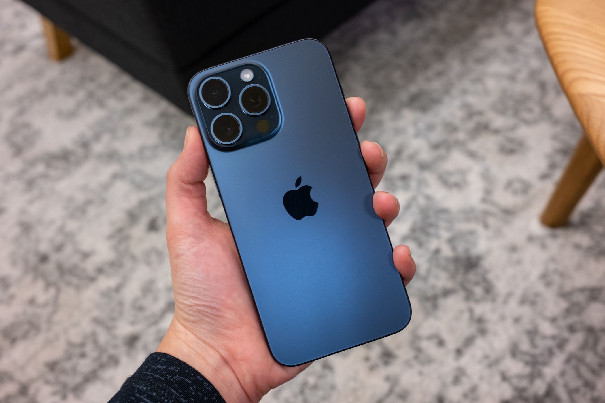 Человек держит iPhone 15 Pro Max.