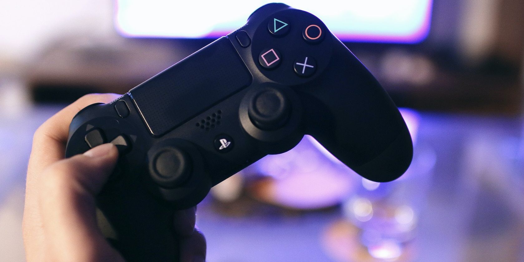 A PS4 controller being held by the D pad