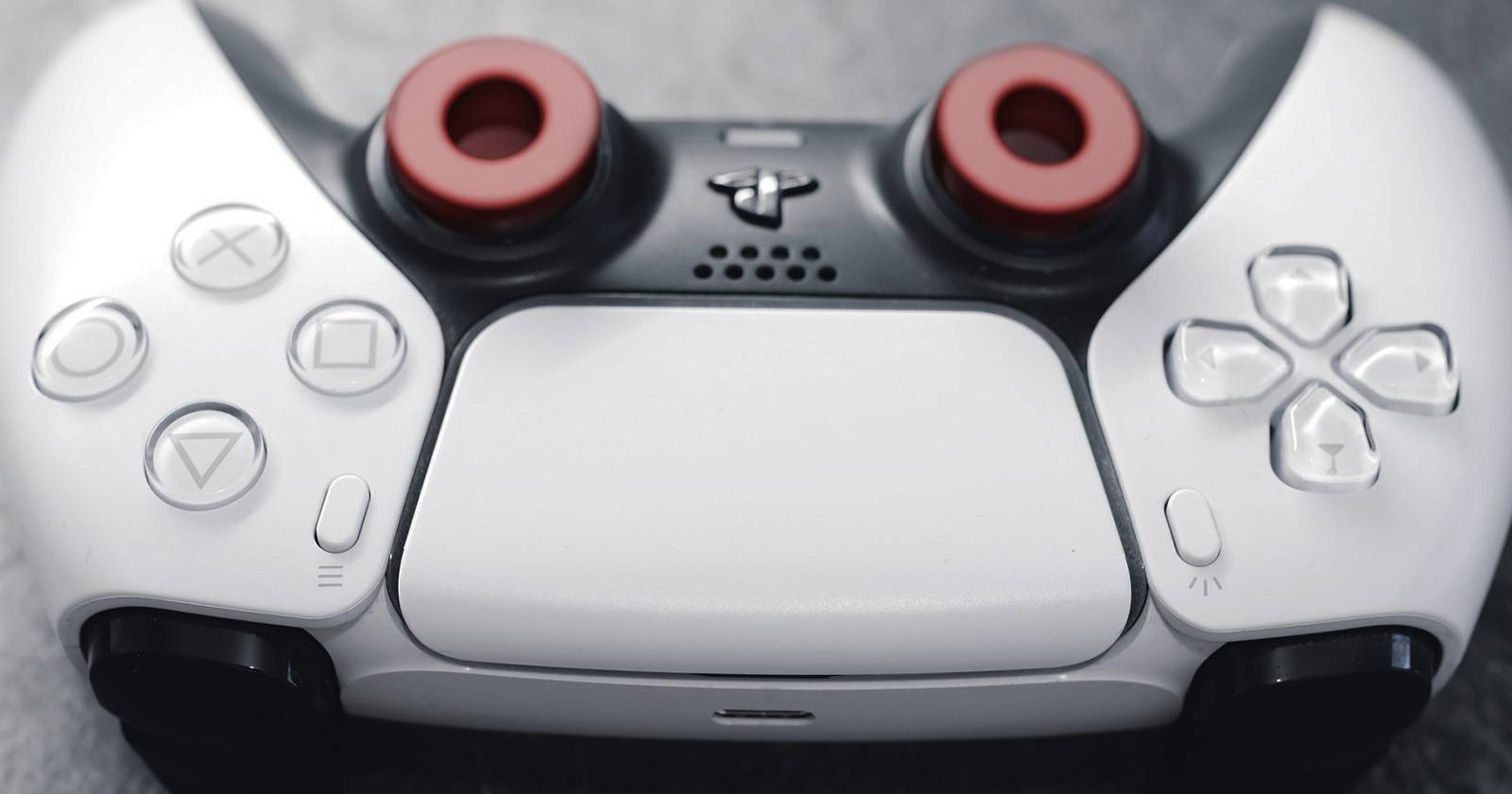 Контроллер PS5 DualSense, красные кружки отмечают джойстики.