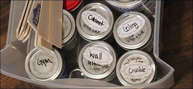 Небольшие стеклянные банки краски с аккуратными этикетками стоят на полке в подсобке