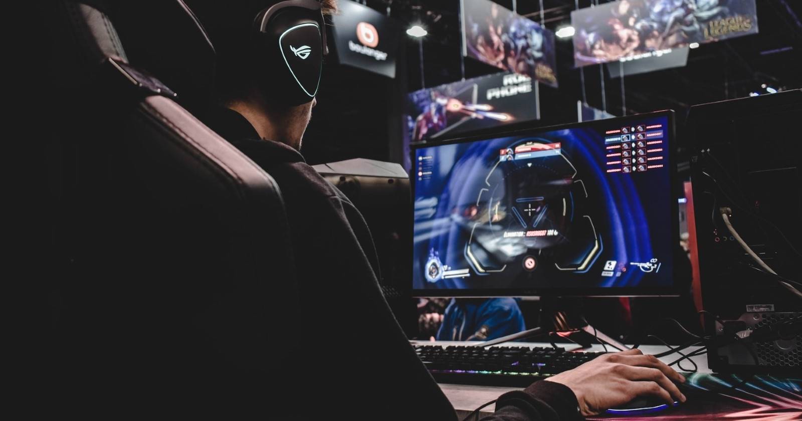 Человек в игровой кресле за ПК, играющий в видеоигру