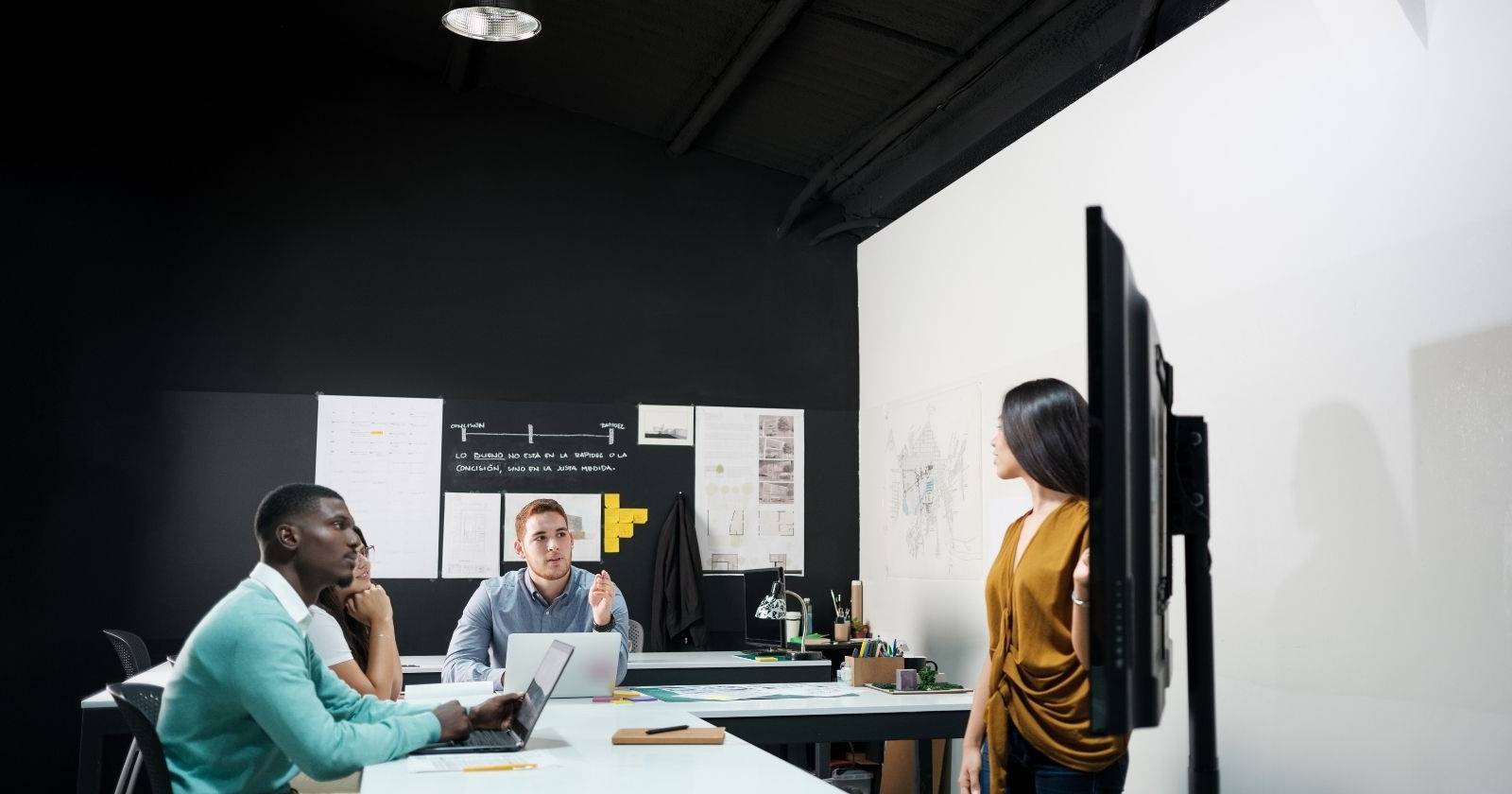 Женщина делает презентацию для двух мужчин в рабочей обстановке