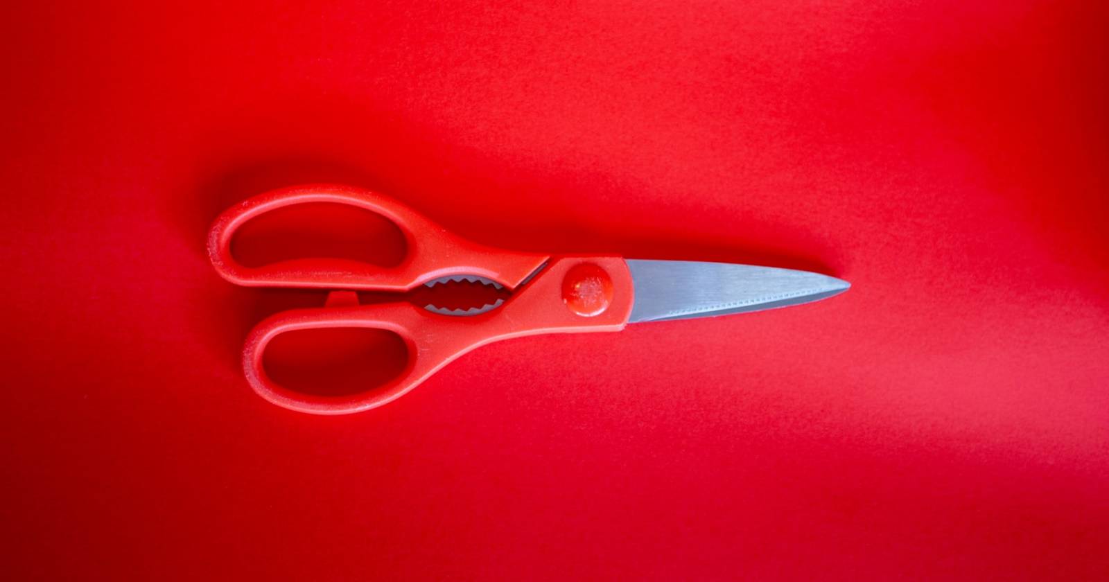 красные ножницы на красном фоне