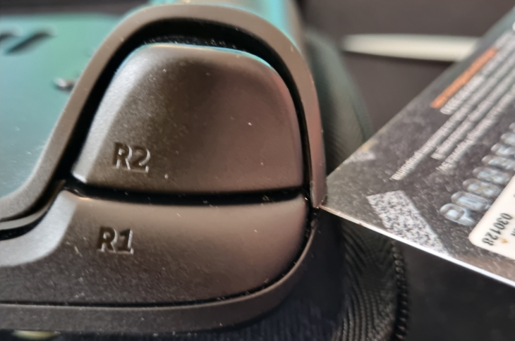 Подденьте заднюю крышку пластиковой лопаткой, начиная с бокового грипа