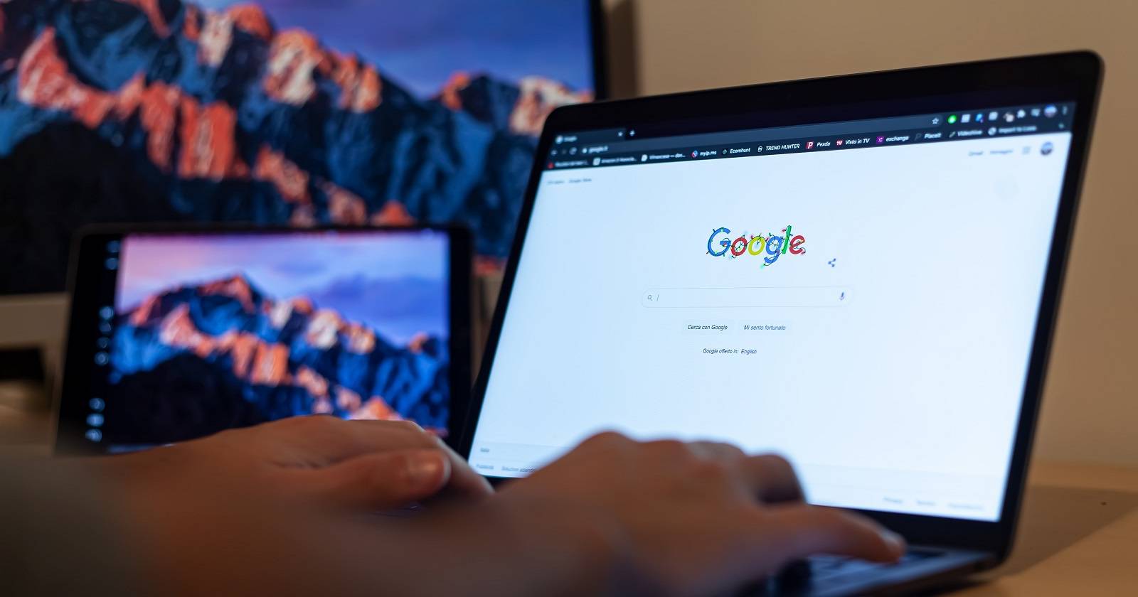 Человек за столом ищет информацию о себе в Google на ноутбуке