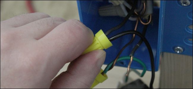 Два черных провода диммера соединены с проводами в коробке с помощью изоляционных колпачков