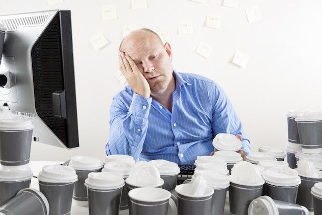 Уставший фрилансер, размышляющий о неоплаченных счетах