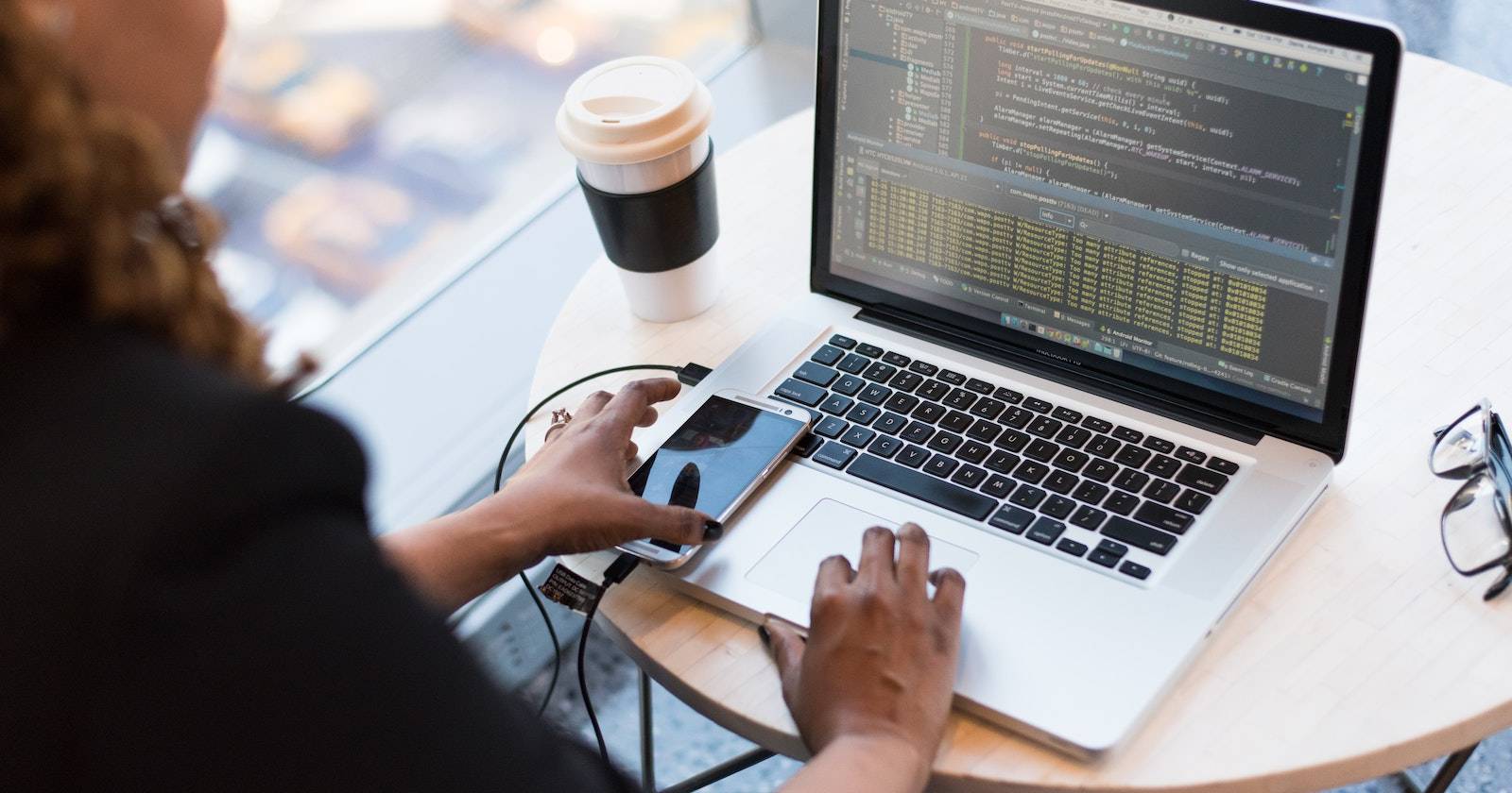 Человек пишет код на серебристом ноутбуке