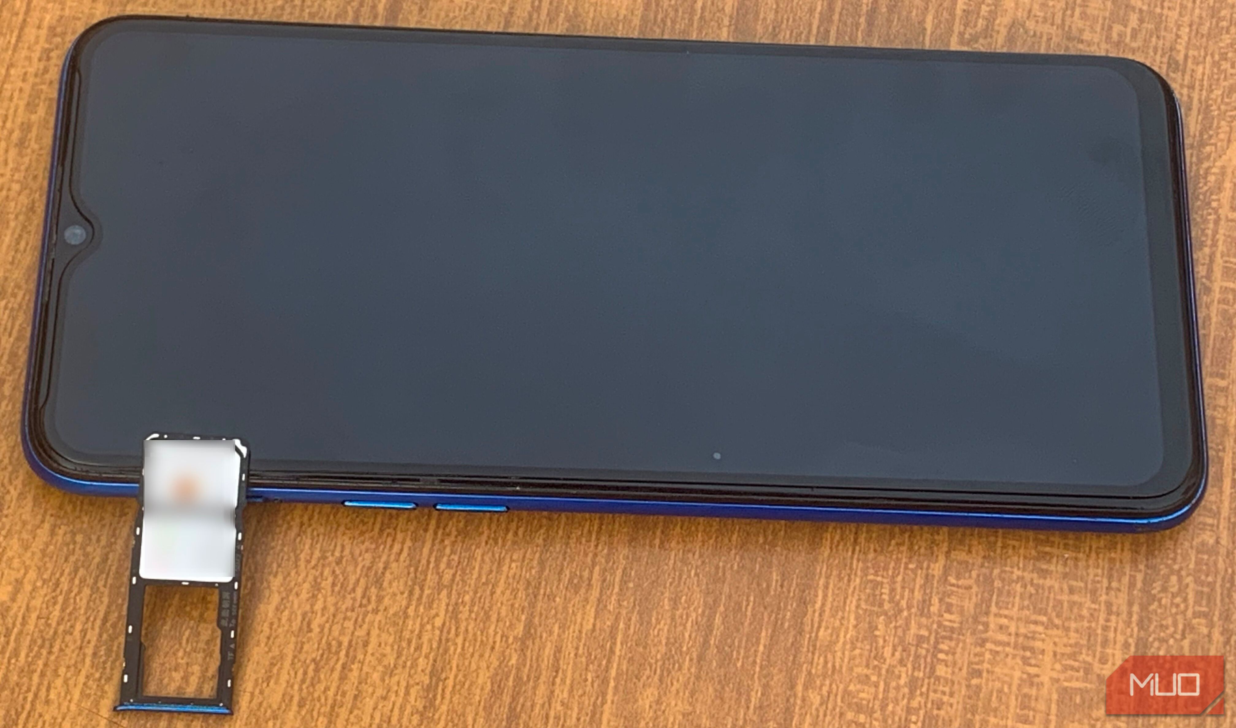 Android-телефон на столе с лотком для SIM рядом