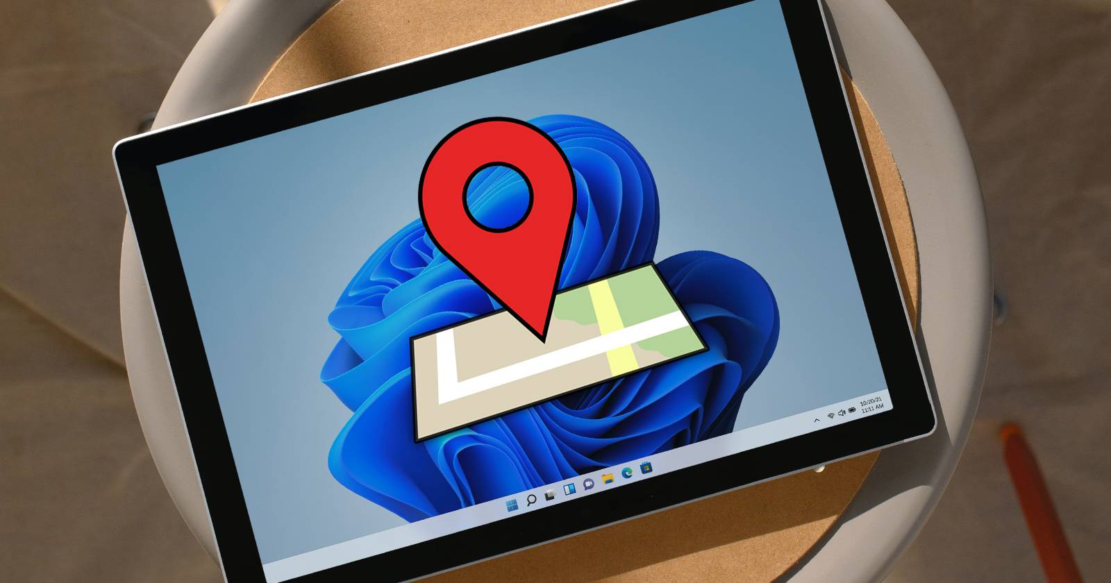 Фотография ноутбука на рабочем столе с включённым экраном и значком поиска устройства