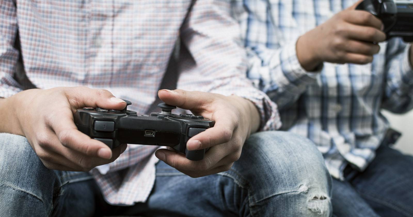Два человека держат контроллеры PlayStation
