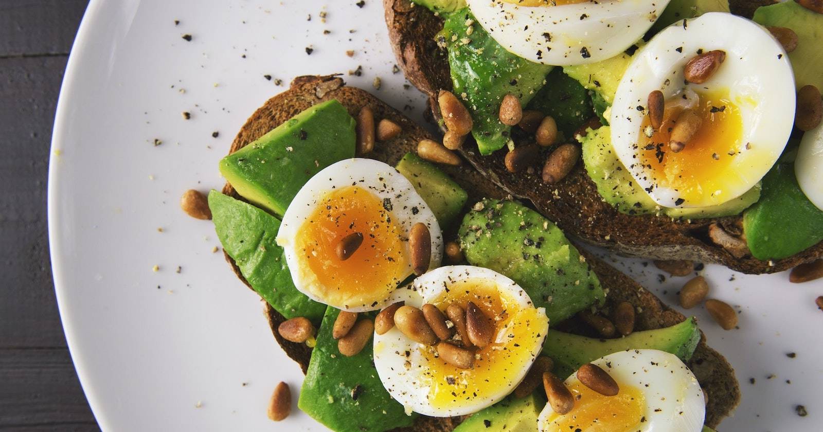 Тарелка с варёными яйцами на тосте с авокадо