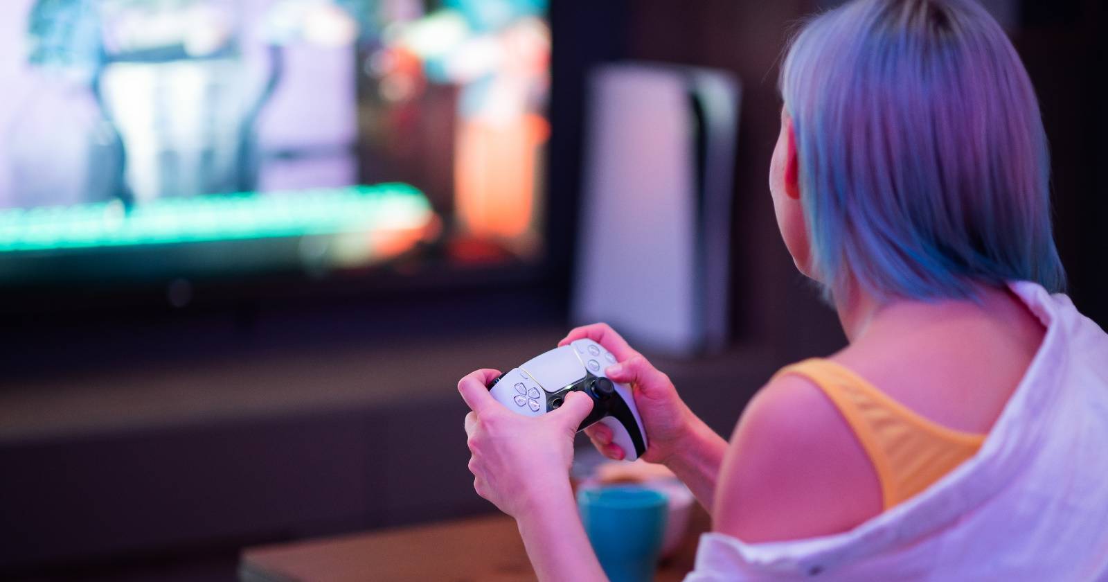 Женщина держит контроллер DualSense и играет на PlayStation 5