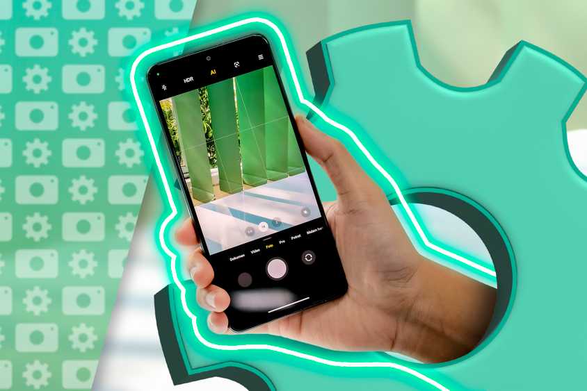 Рука держит телефон с открытой камерой и иконкой настроек