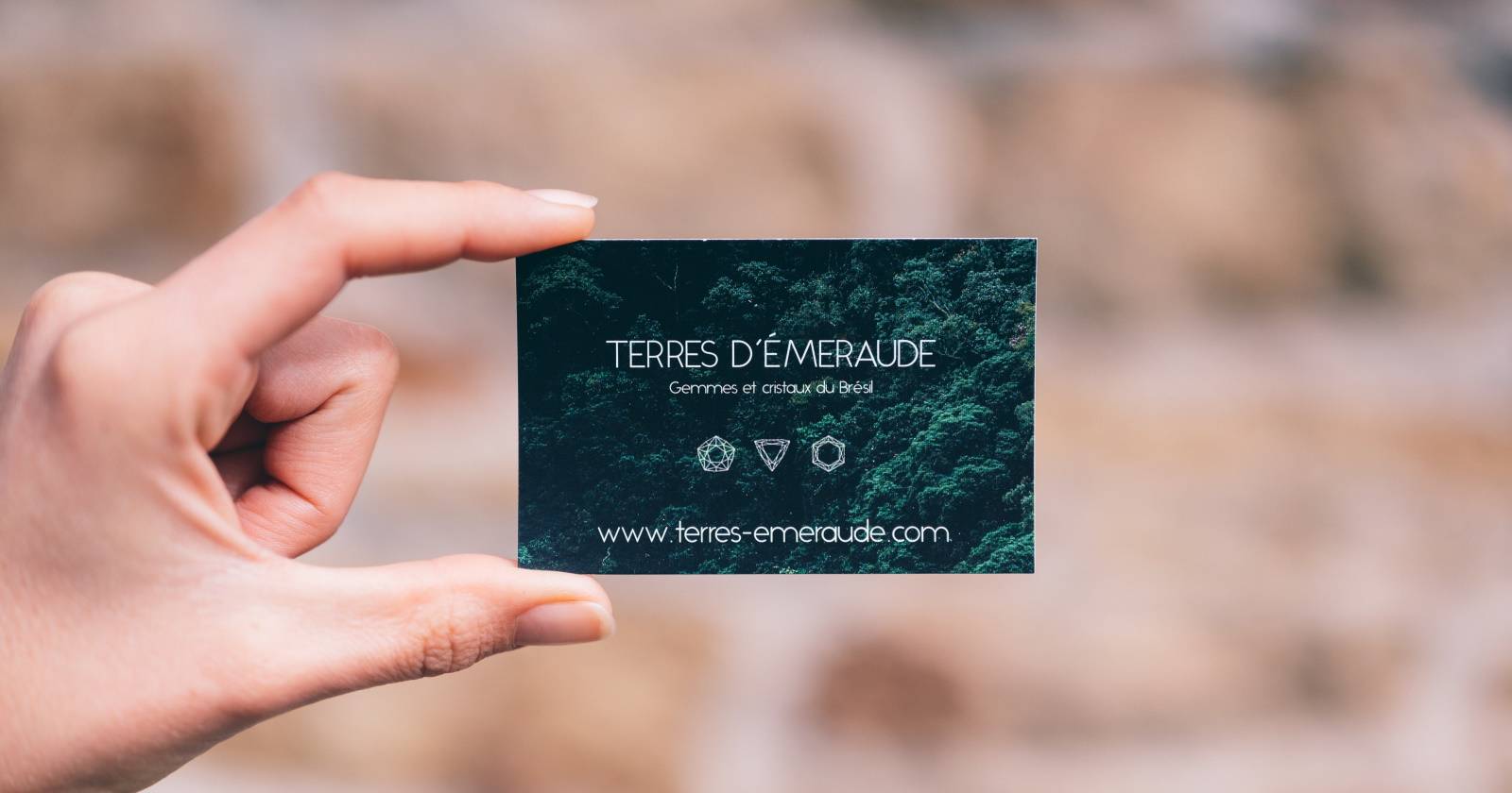 руки, держащие смартфон с цифровой визиткой и бумажной визиткой рядом