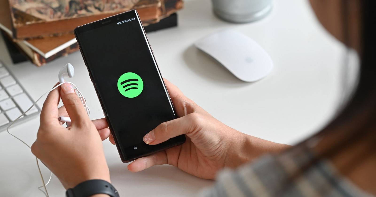 женщина держит телефон с логотипом Spotify