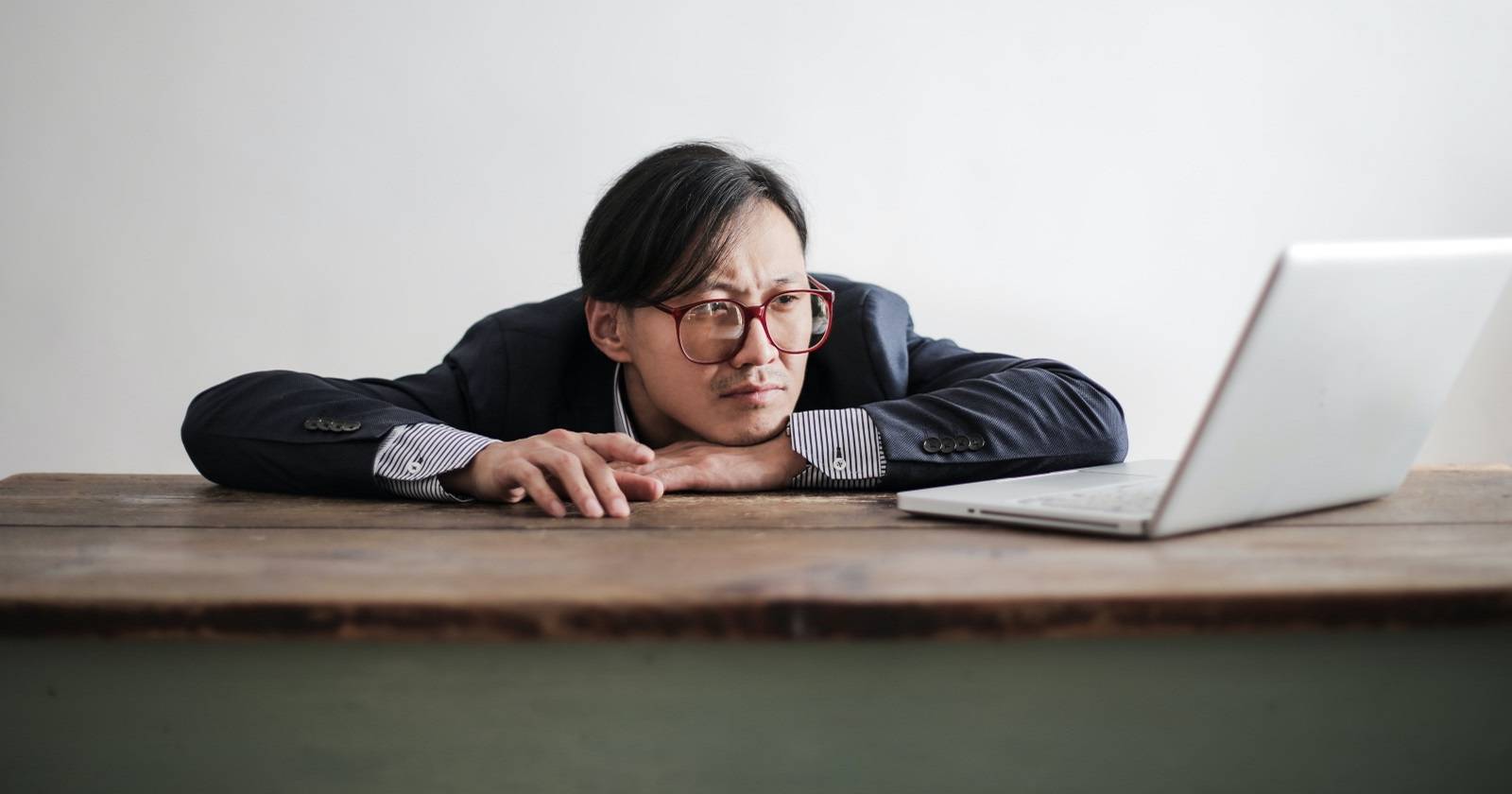 パソコンのそばで不満そうに座る人