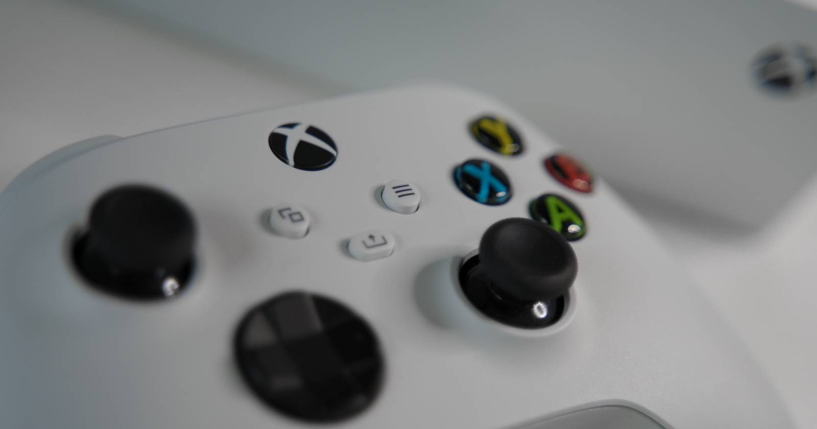 Фотография контроллера Xbox Series S, стоящего перед консолью Xbox Series S