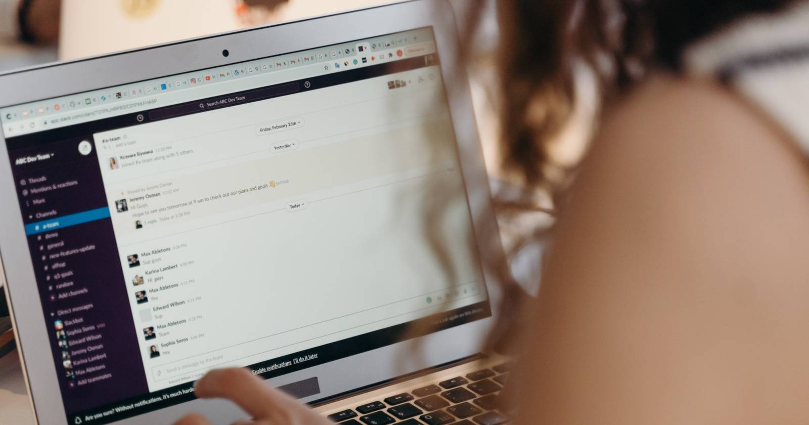 Женщина использует Slack на рабочем компьютере