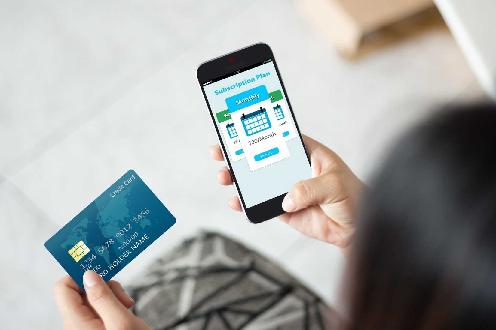 человек использует кредитную карту для покупки подписки на телефоне