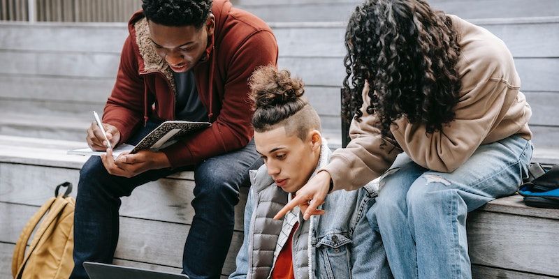 Группа друзей сидит на ступеньках