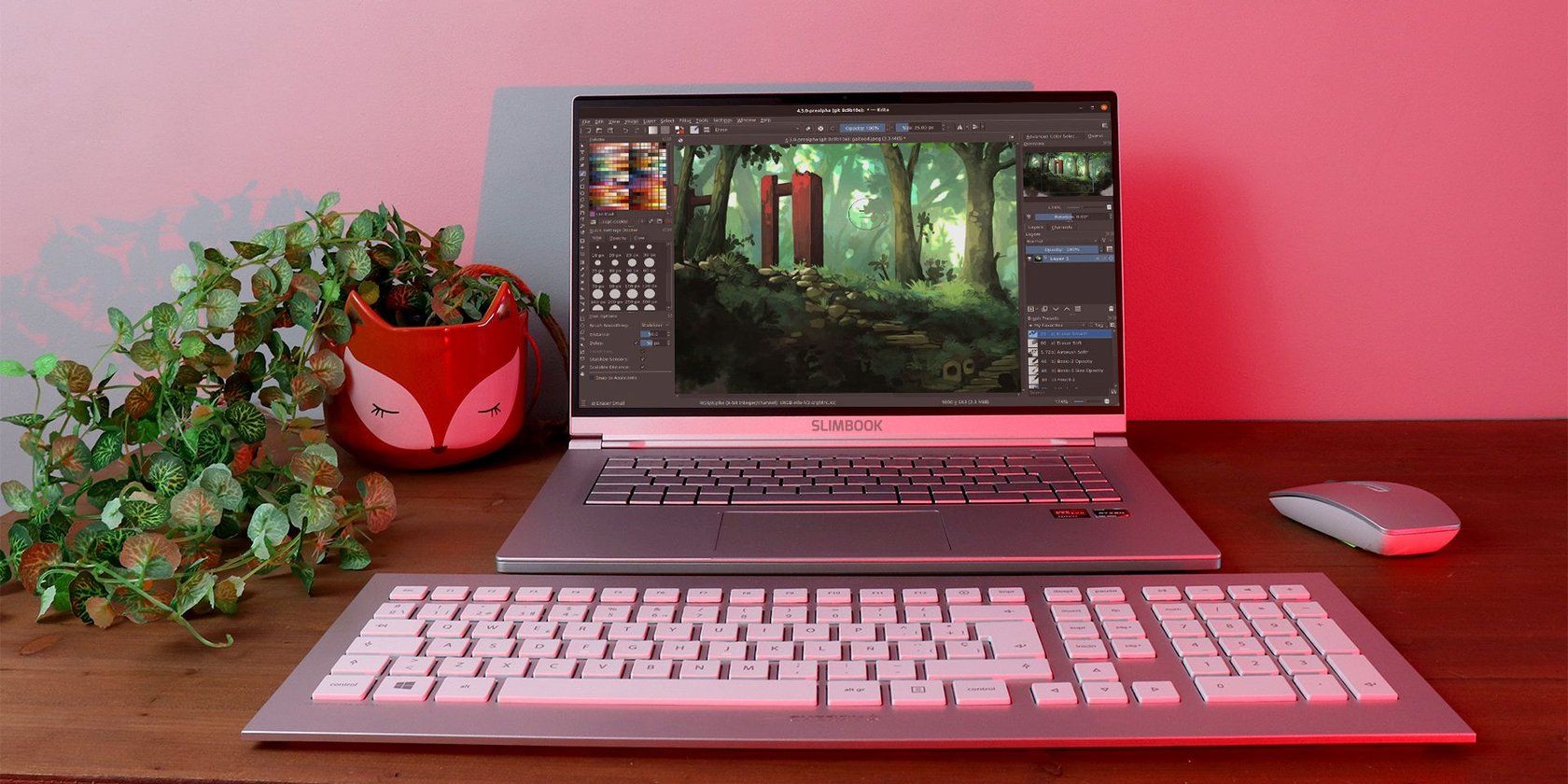 KDE Slimbook laptop in the middle of plants, a keyboard, and a mouse