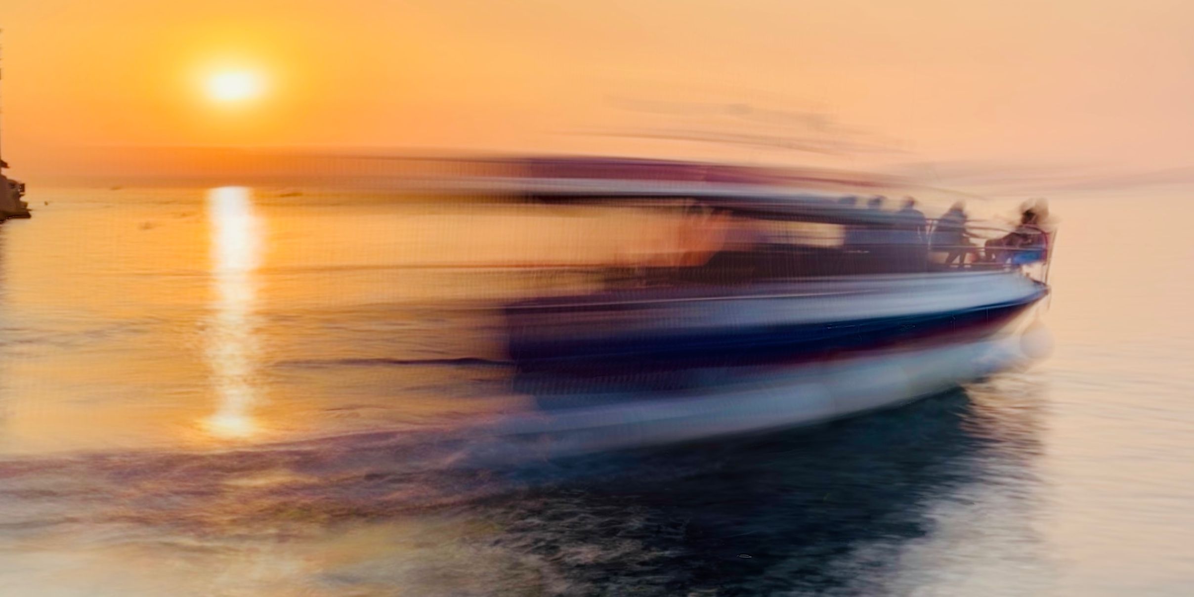 туристический катер оставляет световой след в гавани