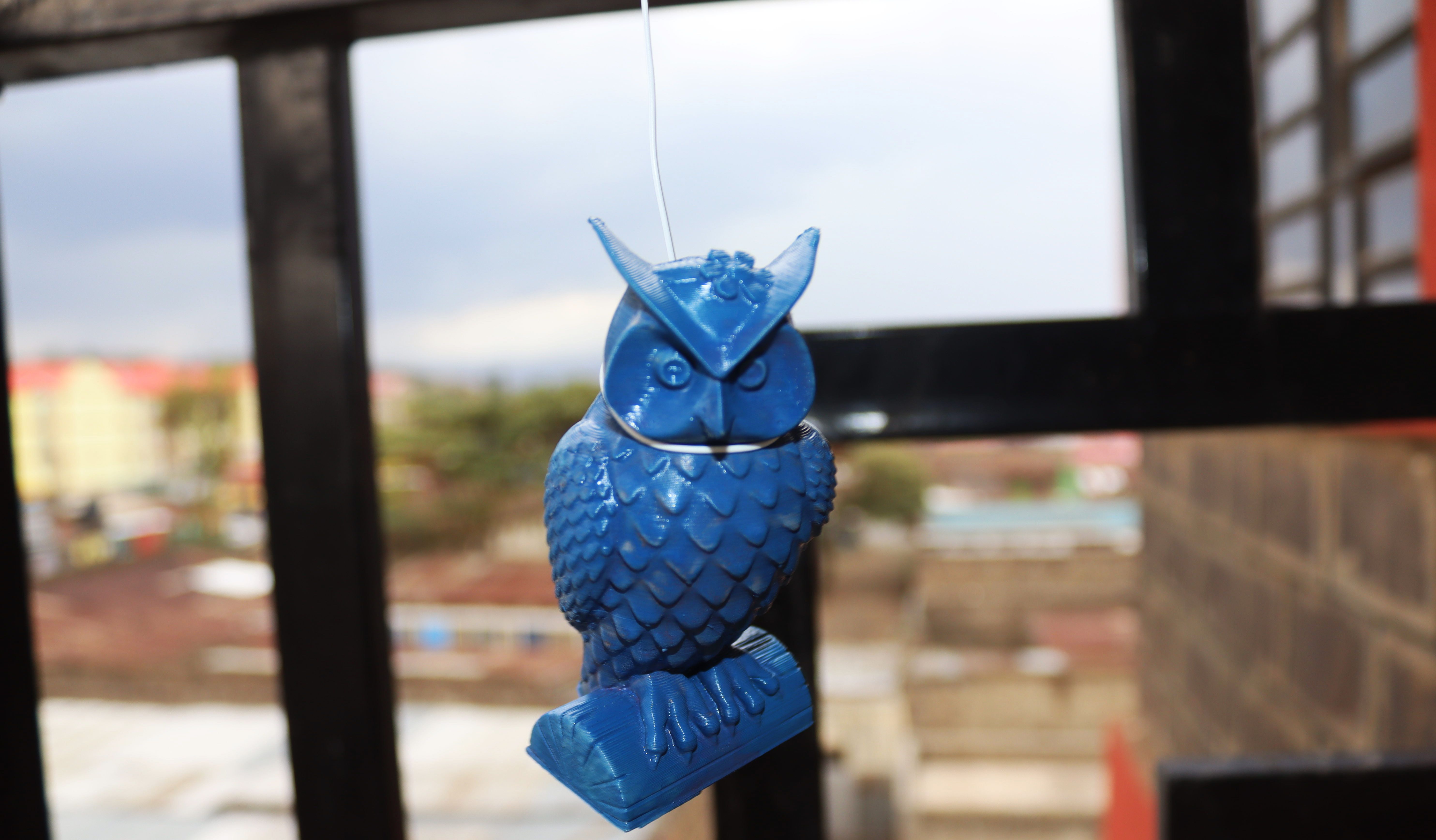 Синяя сова, подвешенная на нити