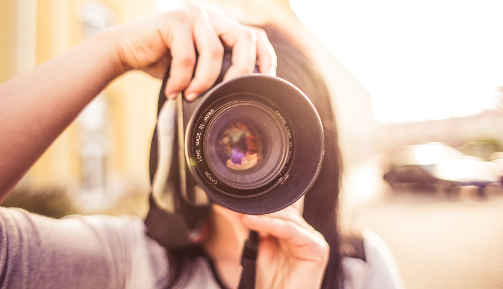 Крупный план женщины с фотоаппаратом, направляющей его