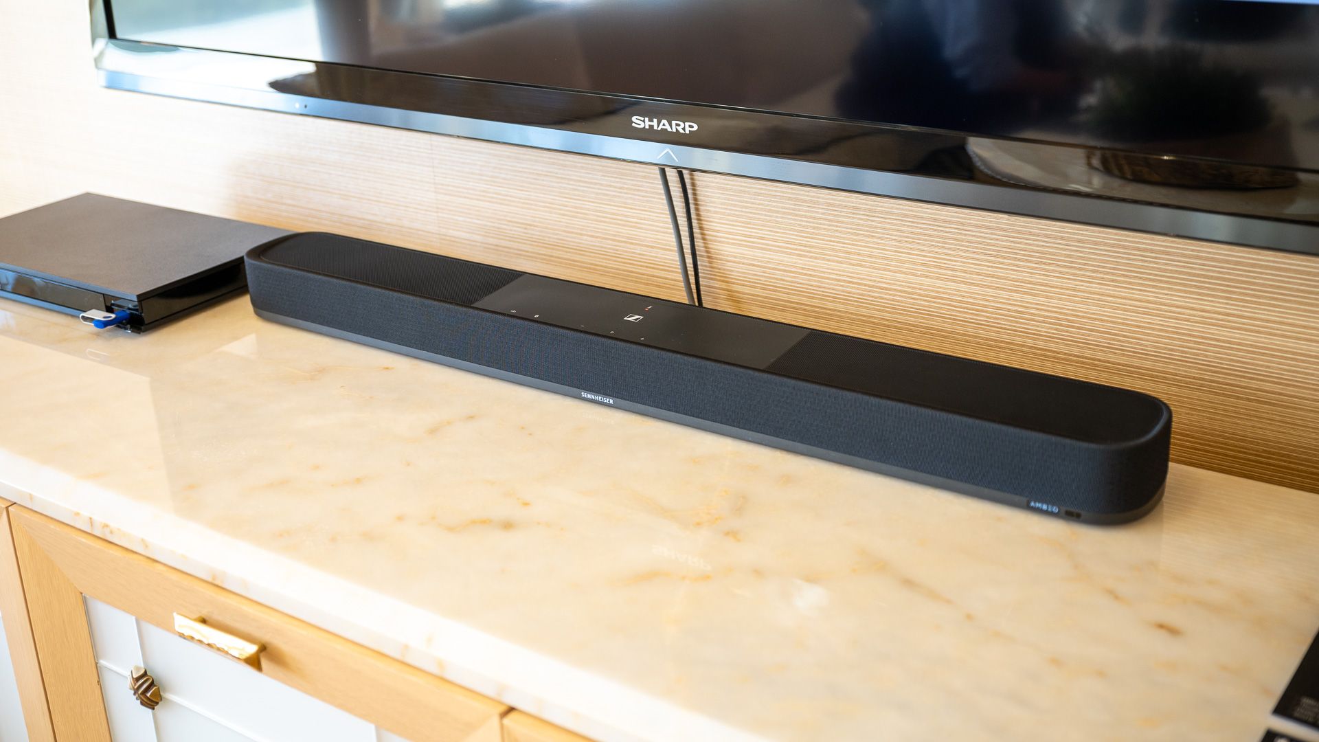 Sennheiser Ambeo Soundbar Plus на тумбе под телевизором