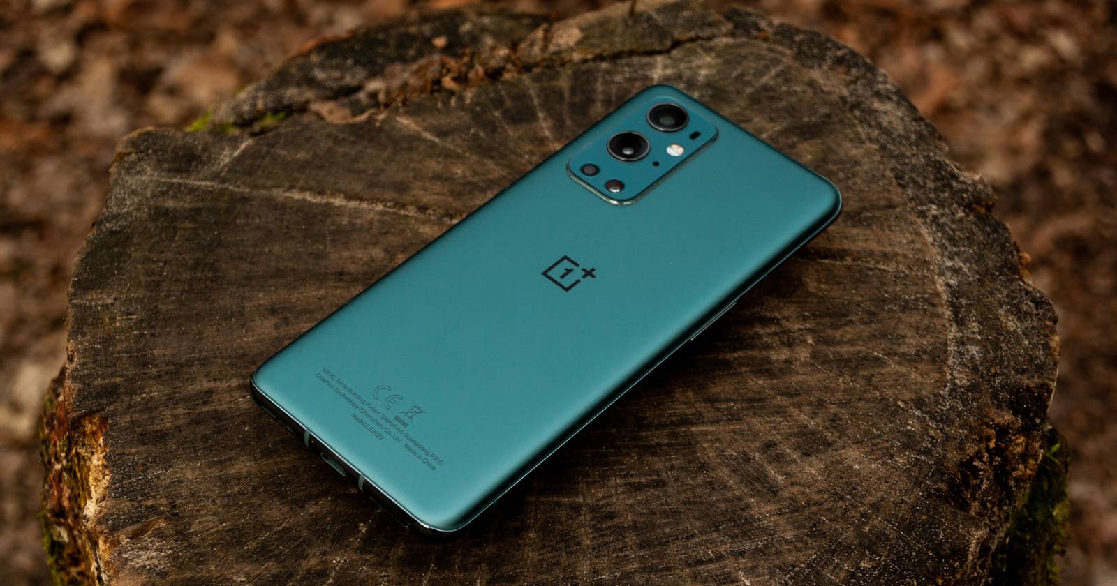 Зелёный телефон OnePlus на бревне