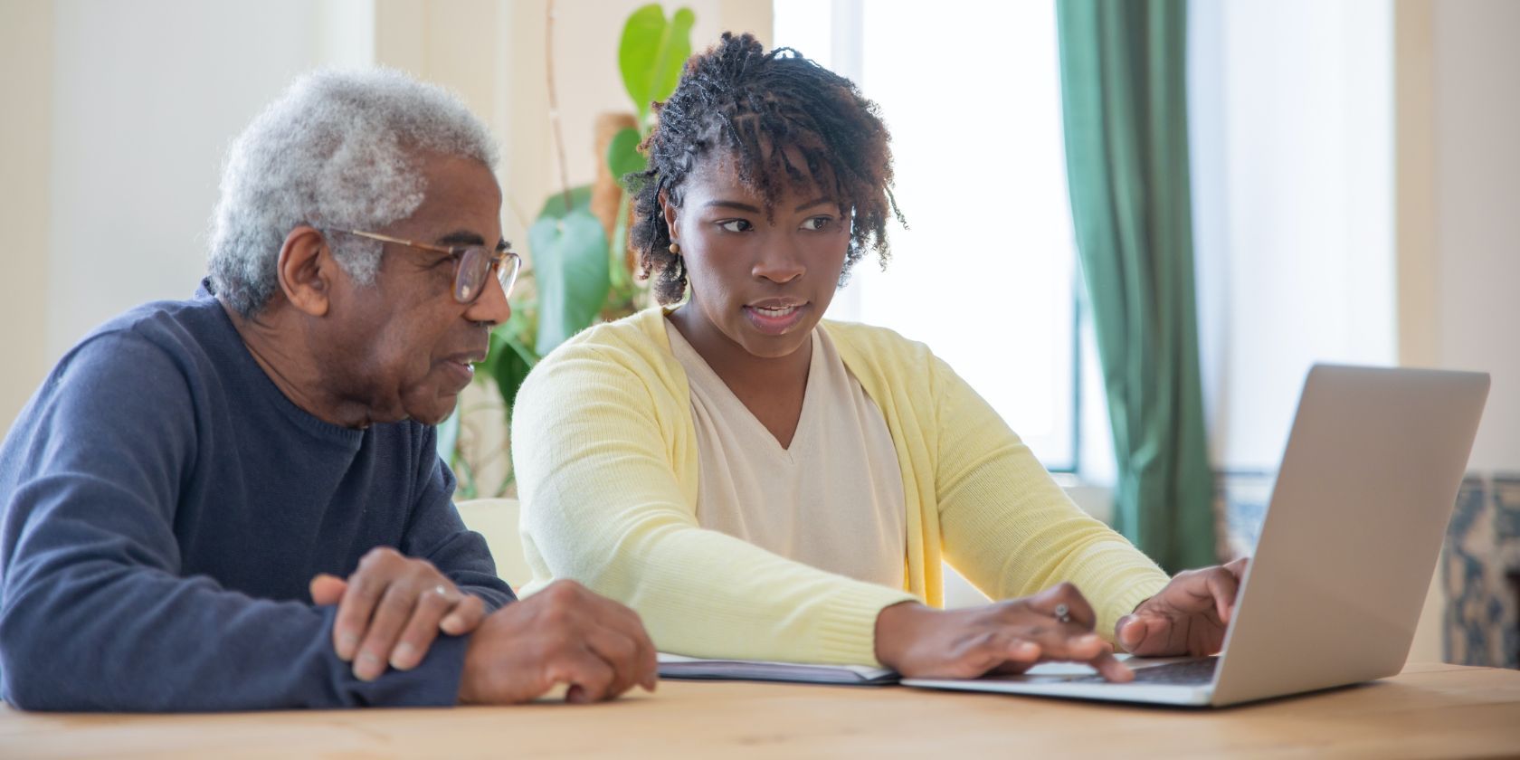 женщина и пожилой мужчина работают за ноутбуком