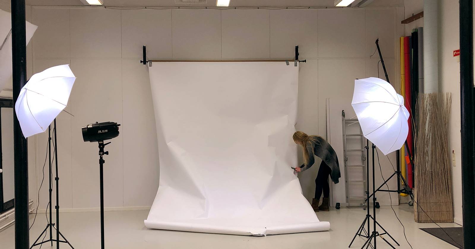 Женщина регулирует студийный фон