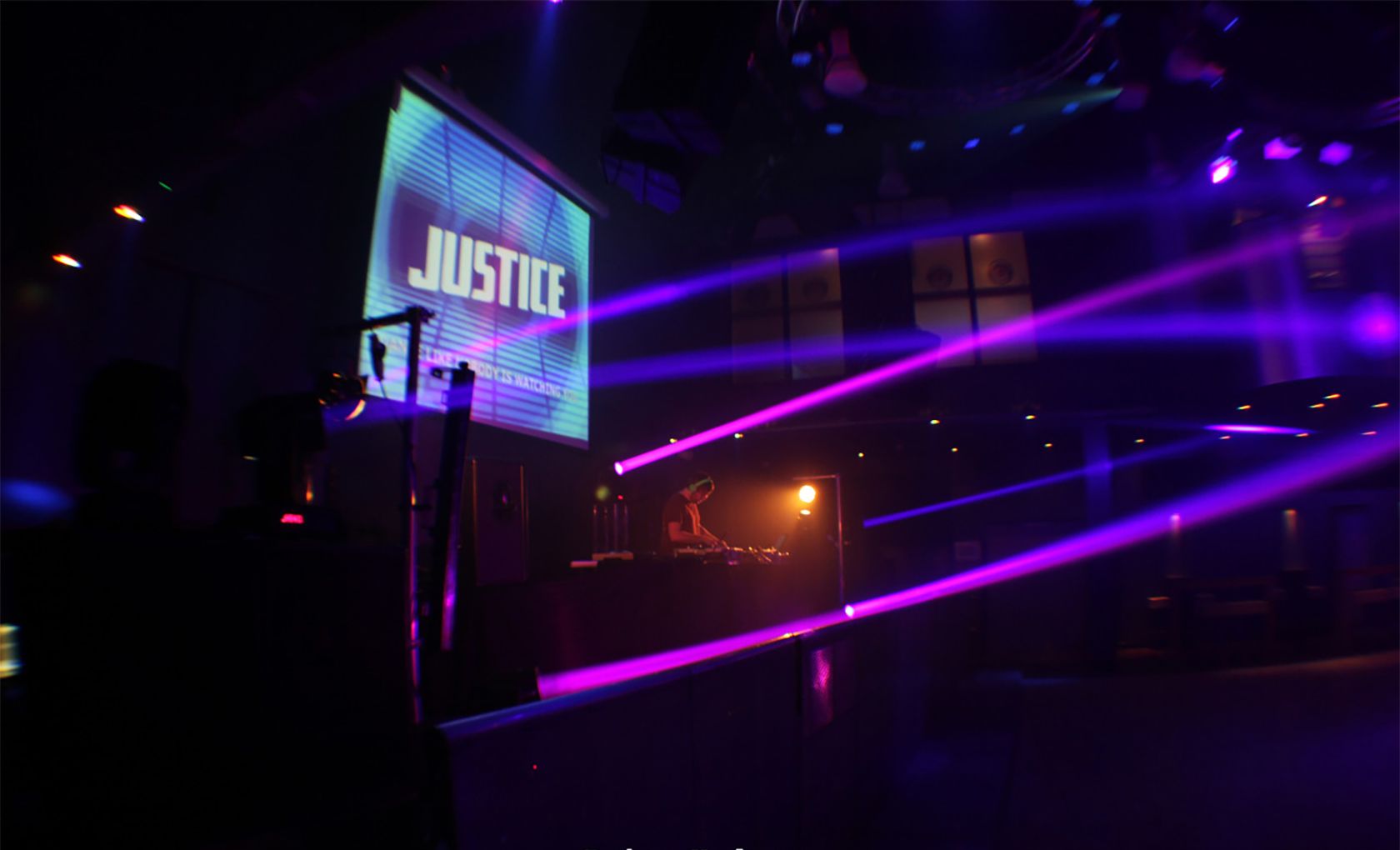DJ в пустом ночном клубе с направленными прожекторами.
