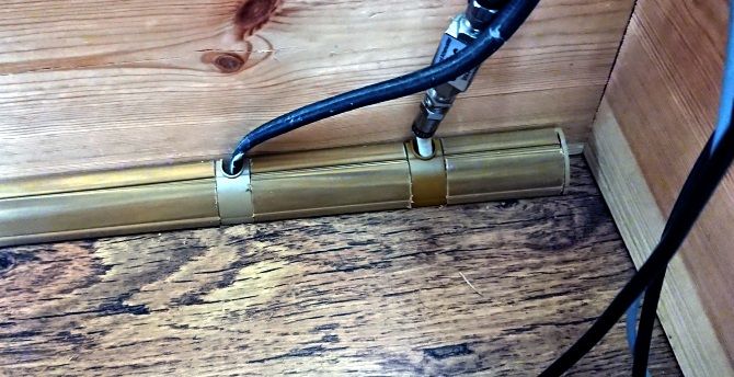 Кабели аккуратно лежат внутри закрытого пластикового короба на стене