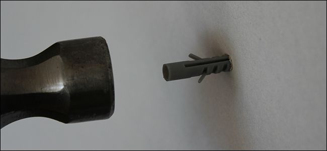 Фото: вбивание пластикового анкера молотком до заподлицо