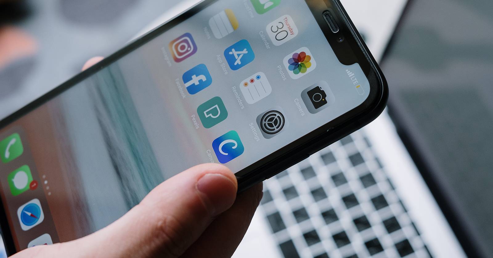 Человек держит iPhone с непрочитанным сообщением