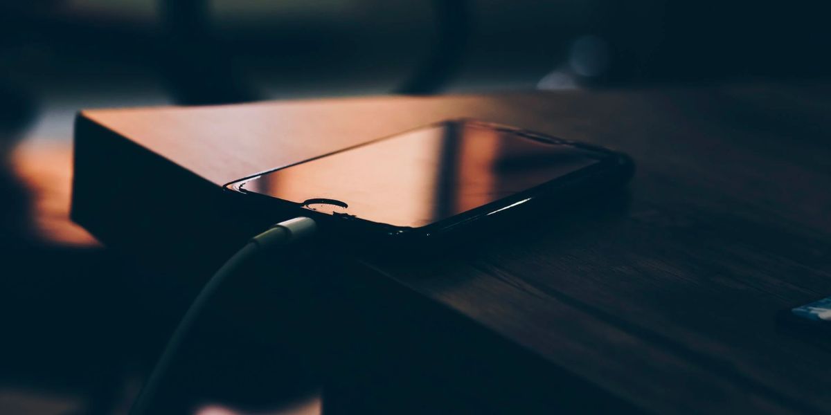 iPhone на столе подключён к зарядке