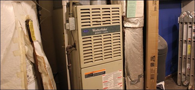 Котёл отопления установлен в подвальном помещении с видимым теплообменником и трубами