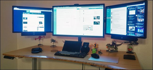 Три монитора, расположенные в углу рабочего стола